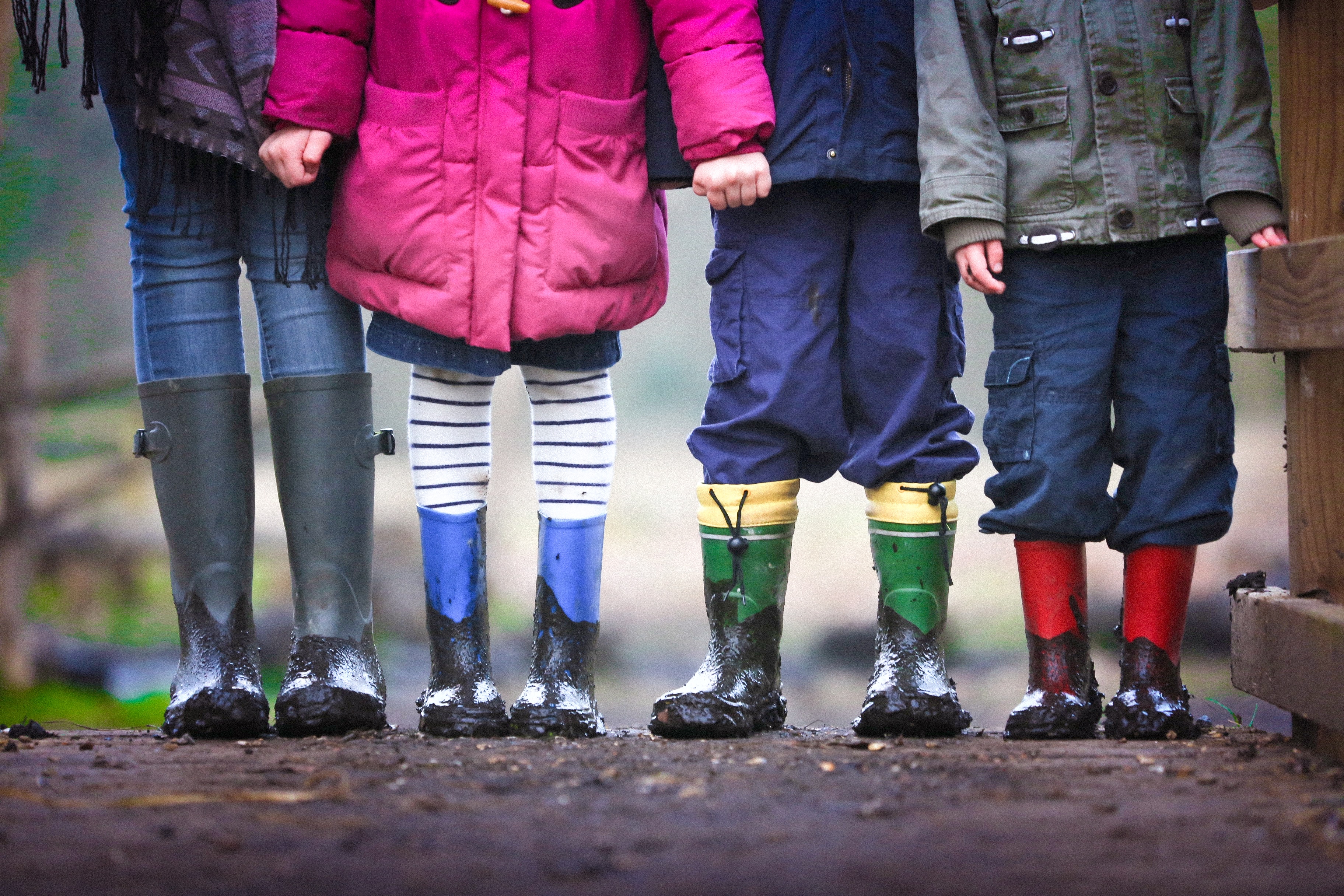 four children wearing wellington boots